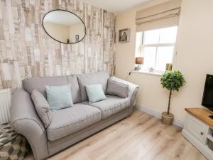 a living room with a couch and a mirror at The Starfish Shack in Filey