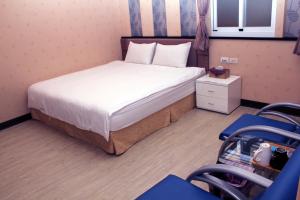 1 dormitorio con 1 cama y 2 sillas azules en Lazy House, en Hengchun