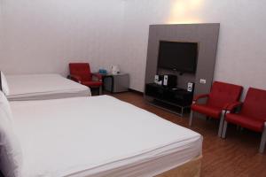 a hotel room with two beds and a flat screen tv at Lazy House in Hengchun