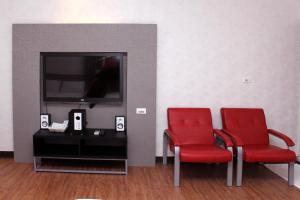 two red chairs in a room with a tv at Lazy House in Hengchun