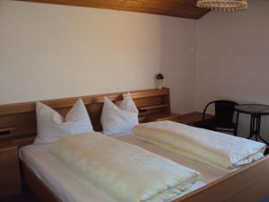 een slaapkamer met 2 bedden en witte kussens bij Aussersalfnerhof in Schenna
