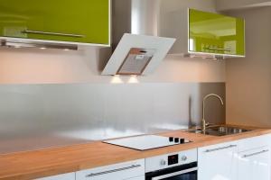 a kitchen with white cabinets and a sink at Gîte Villa Léanne in Namur