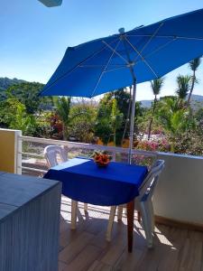 una mesa y sillas azules con una sombrilla azul en Los Bungalitos en Rincon de Guayabitos