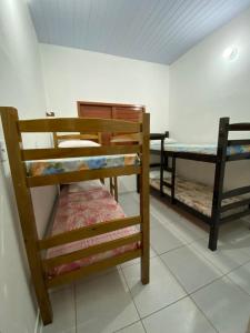 Habitación con 3 literas y mesa. en Casa em Galinhos/RN en Galinhos