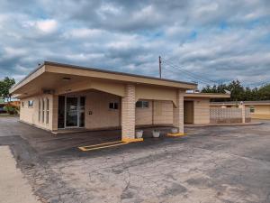 a building with a parking lot in front of it at Budget inn in Kingsville