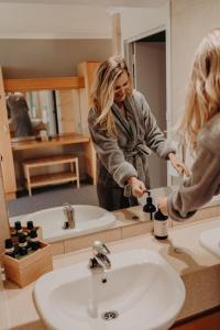 a woman standing in front of a bathroom mirror at Tanah Marah in Margaret River Town