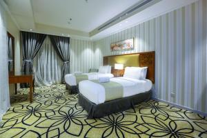 a hotel room with two beds and a piano at Lotaz Hotel Suites - Al Salamah in Jeddah