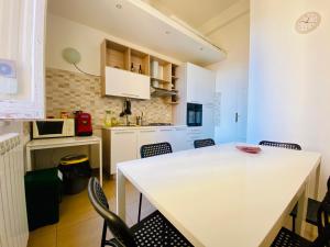 a kitchen with a white table and chairs at Liolà Palermo in Palermo