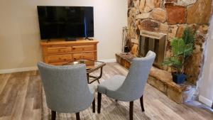 a living room with two chairs and a table and a fireplace at The Orchard in South Jordan