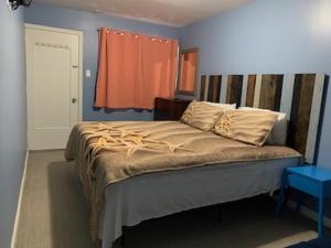 a bedroom with a large bed with an orange window at Twilight Motel in Wildwood