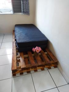 uma cama numa plataforma de madeira com uma planta em Apartamento Beira Mar - Vila Guilhermina em São Paulo