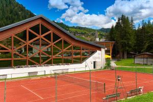 a tennis court in front of a building at Apartments Brunella in La Villa