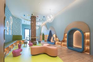 - une salle de jeux pour enfants avec un canapé et une table dans l'établissement Holiday Inn Resort Maoshan Hot-Spring by IHG, à Jurong
