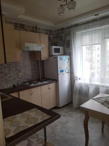 eine Küche mit einem weißen Kühlschrank und einem Fenster in der Unterkunft Квартира в Лузановке2 in Odessa