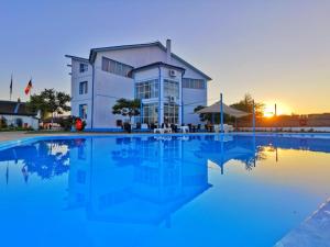 a house with a pool in front of it at Hotel Sunrise in Crisan