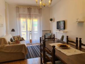 un soggiorno con tavolo, divano e TV di Blue Daisy Apartment a Rapallo