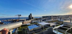 osoba trzymająca teleskop patrząca na miasto w obiekcie Portova Gdynia Sea View w mieście Gdynia