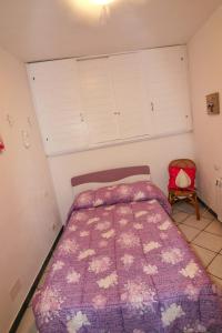 - une chambre avec un lit doté d'une couette violette et d'une chaise dans l'établissement Casa Sandrina, à Levanto