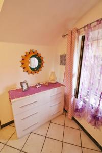 La salle de bains est pourvue d'une commode, d'un miroir et d'une fenêtre. dans l'établissement Casa Sandrina, à Levanto