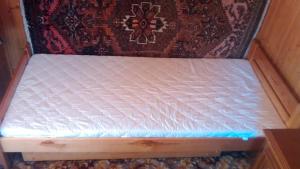 a small bed in a room with a mattress at dom letni in Stare Jabłonki