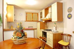 eine Küche mit einem Tisch und einer Blumenvase darauf in der Unterkunft Primettahouse in San Gimignano