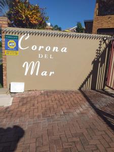 a sign that says corona del mar on a fence at Corona Del Mar 10 in Uvongo Beach