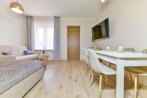 a bedroom with a bed and a table and chairs at Apartament u Ani 2 in Dźwirzyno