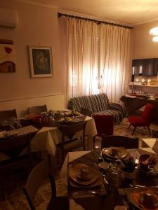 B&B La Dimora dei Professori في ليتشي: غرفة طعام مع طاولات وكراسي وأريكة