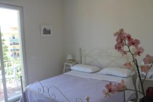 a white bedroom with a bed and a flower at B&B Il Giglio Bianco in Sorrento