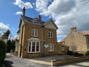 an old brick house with white windows on a street at The Old Manse Pickering in Pickering