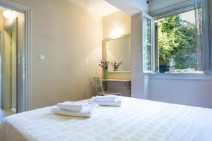 1 dormitorio con 1 cama con 2 toallas en Windward Suite @ Fiscardo waterfront, en Fiskardho
