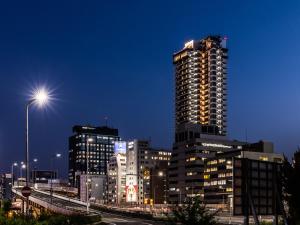 un skyline di notte con un edificio alto di APA Hotel Shin Osaka Eki Tower ad Osaka