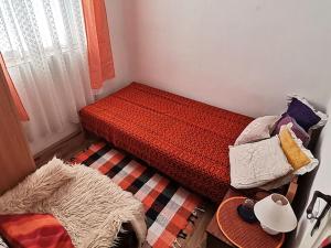 a small bedroom with a bed with a red comforter at "Pivnica i smestaj Jovanovic"- Rogljevacke pivnice in Rogljevo