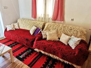 a couch with pillows on it in a living room at "Pivnica i smestaj Jovanovic"- Rogljevacke pivnice in Rogljevo
