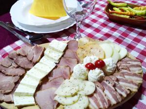 a plate of food with meat and cheese and grapes at "Pivnica i smestaj Jovanovic"- Rogljevacke pivnice in Rogljevo