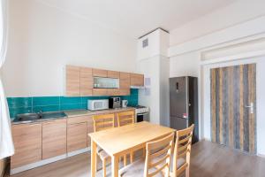 eine Küche mit einem Holztisch und eine Küche mit einem Kühlschrank in der Unterkunft Spacious Apartment Děčín in Děčín