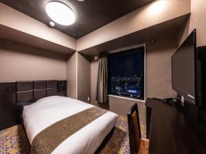 um quarto de hotel com uma cama e uma televisão em APA Hotel Shin Osaka-Eki Tower em Osaka
