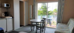 a room with a table and a window and a table and chairs at Hotel La Chaumière in Saint-Jean-de-Monts