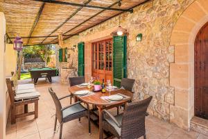 een eetkamer met een tafel en stoelen en een stenen muur bij Finca Es Pujolet in Alcudia