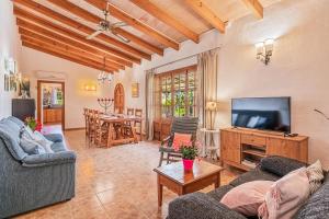 a living room with two couches and a flat screen tv at Finca Es Pujolet in Alcudia