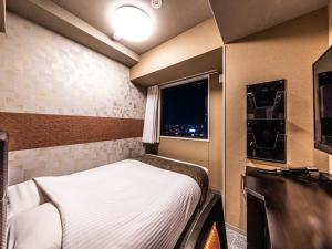 Letto o letti in una camera di APA Hotel Shin Osaka Eki Tower