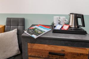 einen Tisch mit Kaffeemaschine und ein Buch darauf in der Unterkunft Gasthof-Gästehaus am Storchenturm in Eisenach
