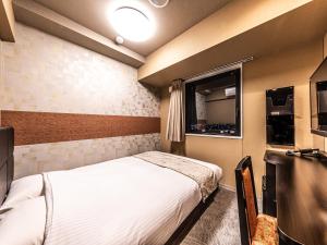 Letto o letti in una camera di APA Hotel Shin Osaka Eki Tower
