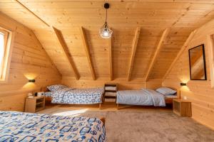 a bedroom in a log cabin with two beds at Green Top in Žabljak