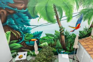 a mural of the jungle with a red bird at MONKÓ - COCO & TROPYCAL APARTMENT o in Torremolinos