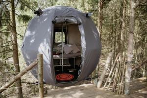 a bed in a tent in the woods at Palapinė medyje in Barkellai
