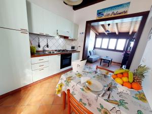 a kitchen with a table with fruit on it at Casa I Sogni In Terrazzo in Marzamemi