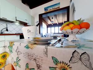 a kitchen with a table with a bowl of fruit on it at Casa I Sogni In Terrazzo in Marzamemi