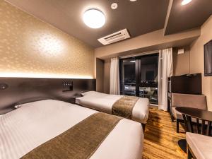 Letto o letti in una camera di APA Hotel Shin Osaka Eki Tower