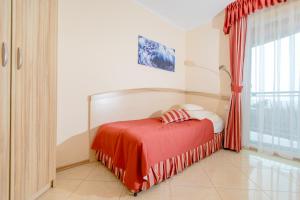 una camera con un letto con una coperta rossa di Villa del Mar a Niechorze